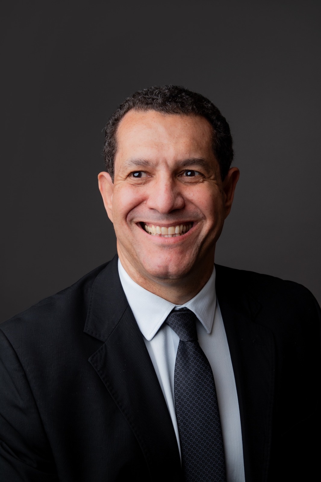 Wagner Brito sorrindo, de terno e gravata